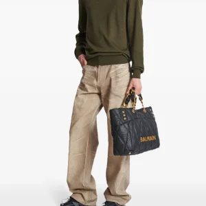 Balmain garment-dyed jeans back view showing rear pockets, designer detailing, premium denim construction, and garment-dyed fabric finish
